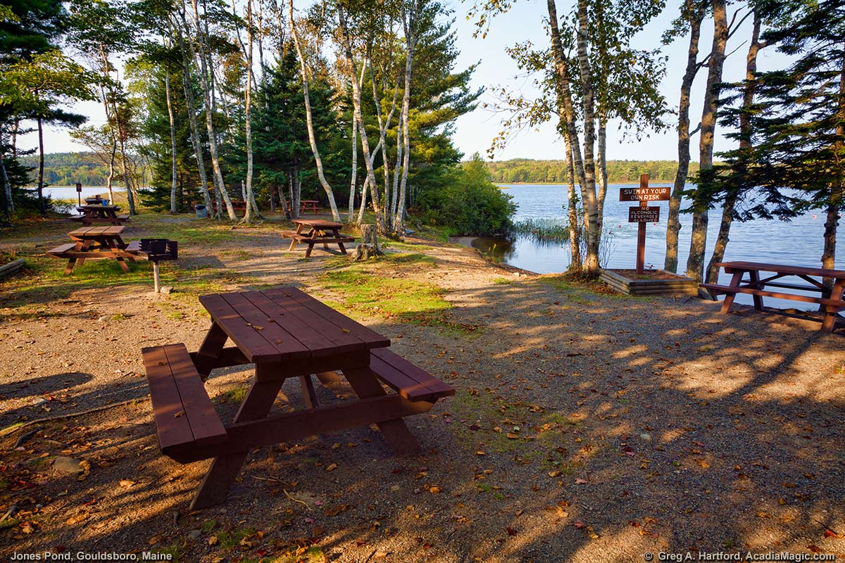 This shows one of the picnic tables next to the shore at Jones Pond in Maine.