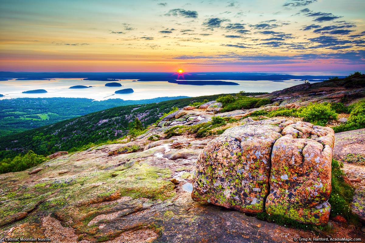 The sun rises just over the horizon as seen from Cadillac Mountain, Maine.