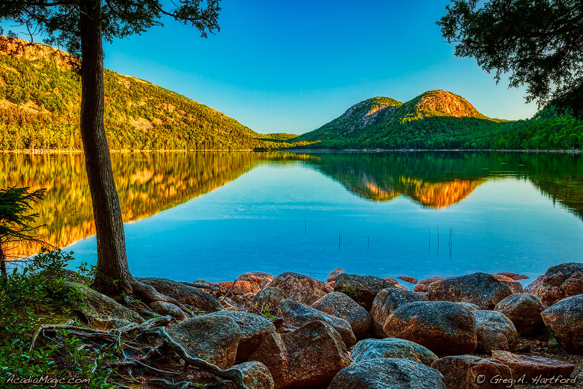 A calm Jordan Pond with reflection of The Bubbles