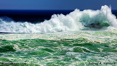 Large ocean wave breaking at The Spindle in front of Otter Cliff at Otter Point in Acadia National Park