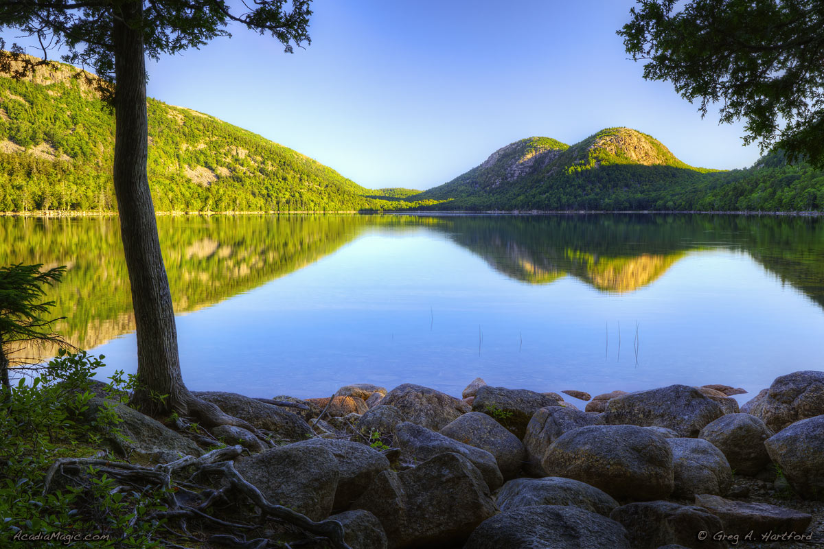 A calm Jordan Pond with reflection of The Bubbles