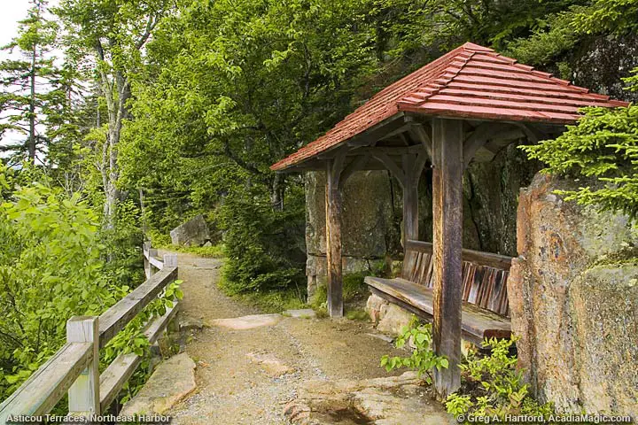 Open style structure with sitting bench and roof that is at lower level