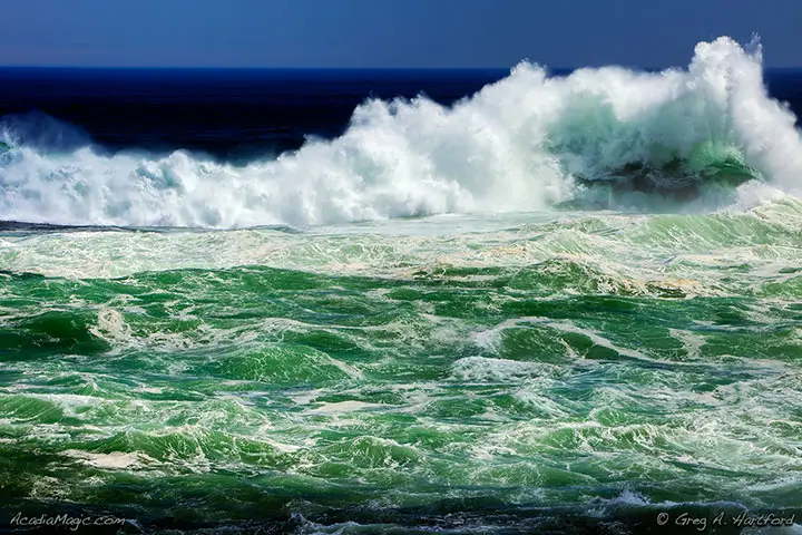 A wave crashes against the Spindle near Otter Cliff in Acadia. Ocean wave hitting the Spindle at Otter Cliff